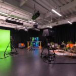 Full TV studio, including green screen, news, and podcast/interview pannels