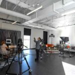 TV Studio with a small corner stage for interviews and an ORRA employee taking pictures